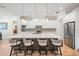 Modern eat-in kitchen features an expansive island and seating, white cabinets, and stainless appliances at 17566 Hyland Ln, Dade City, FL 33523