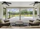 Relaxing screened lanai has comfortable seating and a scenic view of the yard and pool at 17566 Hyland Ln, Dade City, FL 33523