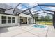 Back of a home featuring a lovely screened in lanai, pool, and outdoor seating area at 17566 Hyland Ln, Dade City, FL 33523