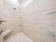 Luxurious tiled shower featuring a built in bench, overhead rainfall shower, and glass shelving at 17566 Hyland Ln, Dade City, FL 33523