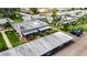 Aerial view of villa showing landscaping, screened lanai, carport, and convenient parking in a peaceful community at 1802 Bedford Ter # 185, Sun City Center, FL 33573