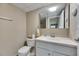 Bright bathroom features a toilet, sink, mirror, and fixtures at 1802 Bedford Ter # 185, Sun City Center, FL 33573