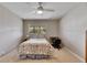 Cozy bedroom with a comfortable bed, window, ceiling fan, small desk and chair, providing a relaxing atmosphere at 1802 Bedford Ter # 185, Sun City Center, FL 33573