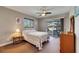 Cozy bedroom featuring a ceiling fan, dresser, and sliding door access to the lanai at 1802 Bedford Ter # 185, Sun City Center, FL 33573