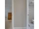 Hallway view showing a bedroom with carpet and a dresser and a bathroom with a toilet and white tile at 1802 Bedford Ter # 185, Sun City Center, FL 33573