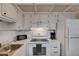 Bright kitchen featuring white appliances and cabinetry with ample counter space and tile flooring at 1802 Bedford Ter # 185, Sun City Center, FL 33573