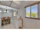 Well-lit kitchen area featuring tile flooring, a large window, and a breakfast table with seating at 1802 Bedford Ter # 185, Sun City Center, FL 33573