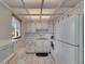 Bright kitchen features white appliances and cabinetry with ample counter space and tile flooring at 1802 Bedford Ter # 185, Sun City Center, FL 33573