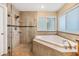 Bright bathroom features a soaking tub, glass shower, and neutral tile at 2016 Chelam Way, Brandon, FL 33511