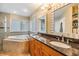 Bright bathroom features a soaking tub, double sinks with granite counters, and modern lighting at 2016 Chelam Way, Brandon, FL 33511