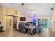 This open-concept living room includes a sliding glass door, cozy seating arrangement, and barn door details at 2016 Chelam Way, Brandon, FL 33511