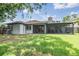 Back exterior with a spacious screened lanai and lush green backyard perfect for relaxing at 2016 Chelam Way, Brandon, FL 33511