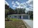 Charming single-story home with lush landscaping and a well-manicured lawn under a blue sky at 2226 Giralda Ave, Spring Hill, FL 34606
