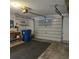 An open garage, with door, shelves, work bench, and large blue trash container at 2226 Giralda Ave, Spring Hill, FL 34606
