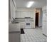 Bright kitchen features white cabinetry, sleek appliances, and black and white tile flooring at 2226 Giralda Ave, Spring Hill, FL 34606