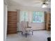 Bright living room featuring bookshelves, vertical blinds, and comfortable seating at 2226 Giralda Ave, Spring Hill, FL 34606