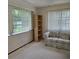 The living room has a sofa and bookshelves, natural lighting, and is cozy at 2226 Giralda Ave, Spring Hill, FL 34606