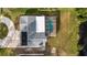 Aerial view of the property showcasing the house, pool, screened enclosure, and surrounding landscape at 239 Freeport Ne Ave, St Petersburg, FL 33702