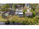 Aerial view of a home with a pool, screened enclosure, and proximity to a pond in a residential neighborhood at 239 Freeport Ne Ave, St Petersburg, FL 33702