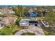 Aerial view of home near a pond, featuring solar panels, screened patio, and a large yard at 239 Freeport Ne Ave, St Petersburg, FL 33702