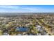 Expansive aerial view of a neighborhood with lush trees and a pond in the foreground on a sunny day with a clear blue sky at 239 Freeport Ne Ave, St Petersburg, FL 33702