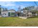 Backyard view of house with enclosed pool, bay window and well maintained grassy yard at 239 Freeport Ne Ave, St Petersburg, FL 33702