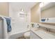 Well-lit bathroom with a shower-tub combo, white tile, and a marble vanity, offering a clean and comfortable space at 239 Freeport Ne Ave, St Petersburg, FL 33702