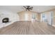 Spacious living room with modern flooring, white fireplace, and open doorway to other living spaces at 239 Freeport Ne Ave, St Petersburg, FL 33702