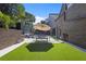 Backyard oasis featuring artificial grass, stylish outdoor furniture, and a shade umbrella for comfortable lounging at 2902 W Fair Oaks Ave, Tampa, FL 33611