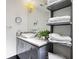 Modern bathroom features a vessel sink, gray cabinetry with square hardware, and open shelving at 2902 W Fair Oaks Ave, Tampa, FL 33611
