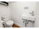 Modern powder room featuring a sleek wall-mounted sink, toilet, and hardwood flooring at 2902 W Fair Oaks Ave, Tampa, FL 33611