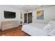Modern bedroom with wood floors, ensuite bathroom and a sleek dresser with TV for ultimate convenience and style at 2902 W Fair Oaks Ave, Tampa, FL 33611