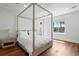Bright bedroom with a four-poster bed, hardwood floors, and a view to the outside, creating a cozy retreat at 2902 W Fair Oaks Ave, Tampa, FL 33611