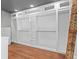 Spacious walk-in closet featuring custom white shelving, drawers, and ample storage space on a wooden floor at 2902 W Fair Oaks Ave, Tampa, FL 33611