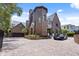 Elegant brick home features an attached garage and circular paver driveway and black car parked in front at 2902 W Fair Oaks Ave, Tampa, FL 33611
