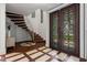 Elegant foyer with unique tile design, modern staircase, and stylish double doors at 2902 W Fair Oaks Ave, Tampa, FL 33611