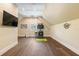 Finished bonus room with a golf simulator, TV, hardwood floors, and plenty of open space at 2902 W Fair Oaks Ave, Tampa, FL 33611