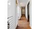 Hallway with hardwood flooring, metal railings, white walls, and modern lighting fixtures at 2902 W Fair Oaks Ave, Tampa, FL 33611