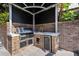 Outdoor kitchen equipped with a built-in grill, sink, and mini fridge, perfect for al fresco dining and entertaining at 2902 W Fair Oaks Ave, Tampa, FL 33611