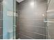 Modern bathroom with contemporary gray tile, a glass shower door, and a sleek, adjustable shower head at 2902 W Fair Oaks Ave, Tampa, FL 33611