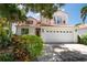 Charming two-story home featuring a tile roof, a two-car garage, and a well-manicured front yard at 2969 La Concha Dr, Clearwater, FL 33762