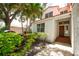 Inviting home entrance with a tile roof, a garden, and a detailed wooden front door at 2969 La Concha Dr, Clearwater, FL 33762