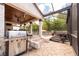 Outdoor kitchen with grill and covered patio with wood ceiling overlooking the pool and lounge area at 2969 La Concha Dr, Clearwater, FL 33762