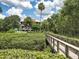 Beautiful condo complex featuring tropical landscaping, pool area, and access via a charming wooden bridge at 300 S Florida Ave # 600L, Tarpon Springs, FL 34689