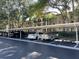 Exterior view of a condominium complex showing parking spaces, trees and landscaping on a sunny day at 3077 Casa Del Sol Cir # 207, Clearwater, FL 33761