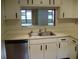 Kitchen featuring a stainless steel dishwasher, updated cabinets, and a pass-through window at 3077 Casa Del Sol Cir # 207, Clearwater, FL 33761