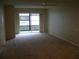Living room featuring carpeted floors and sliding glass doors leading to a balcony at 3077 Casa Del Sol Cir # 207, Clearwater, FL 33761