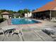Community pool with lounge chairs and outdoor seating area at 3077 Casa Del Sol Cir # 207, Clearwater, FL 33761