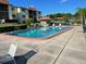 Community pool surrounded by lounge chairs with a gazebo, nestled amongst landscaped grounds and residential buildings at 3077 Casa Del Sol Cir # 207, Clearwater, FL 33761