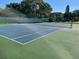 Community tennis court surrounded by a fence and landscaping, offering a space for active recreation at 3077 Casa Del Sol Cir # 207, Clearwater, FL 33761